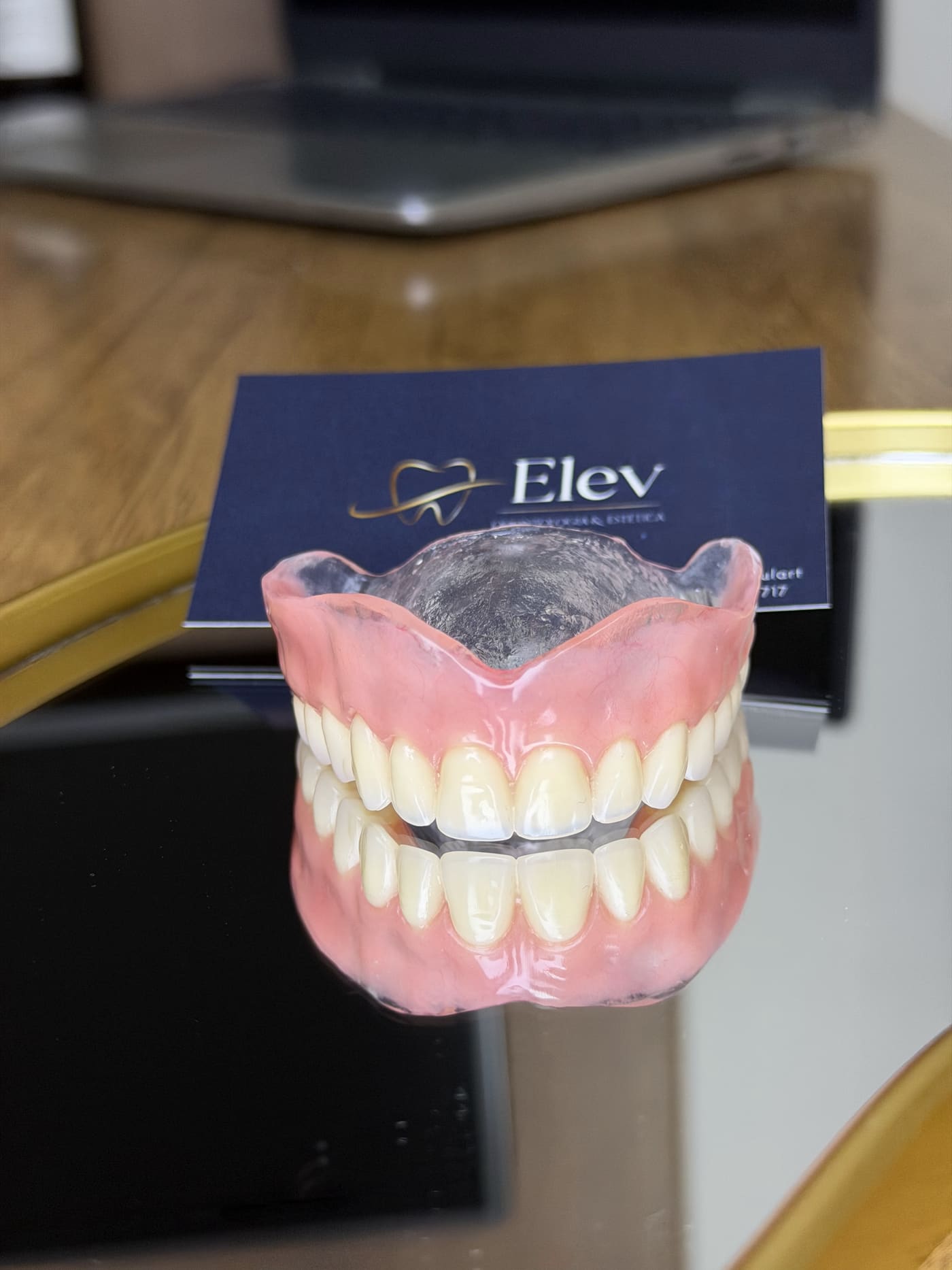 Detalhe de uma prótese total apoiada na bancada da Elev