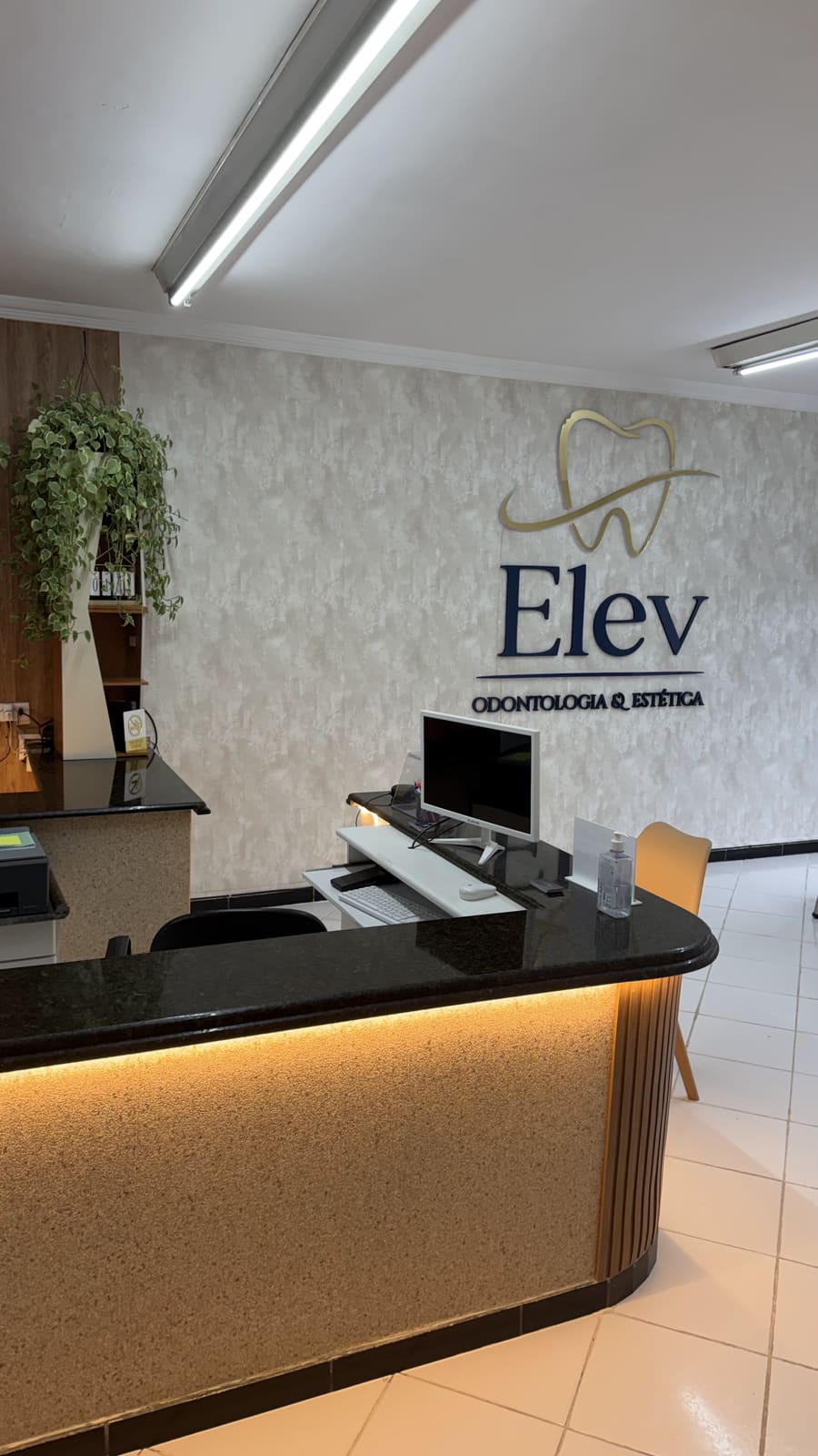 Recepção da Elev em enquadramento vertical, com o letreiro da marca ao fundo